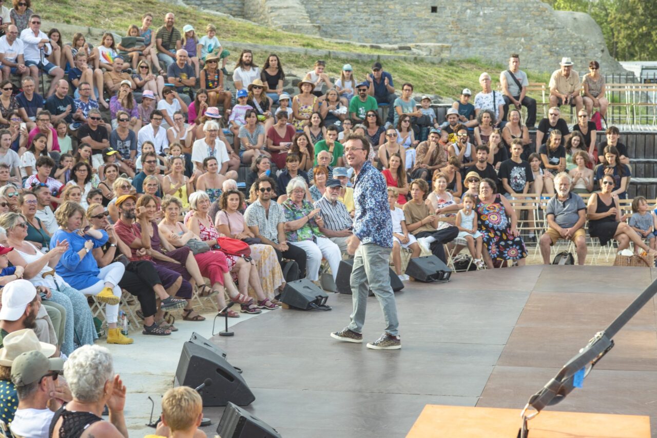 Festival d'Alba 2023. Alain Reynaud, président de la Cascade devant le public installé dans le Théâtre Antique D'Alba la Romaine