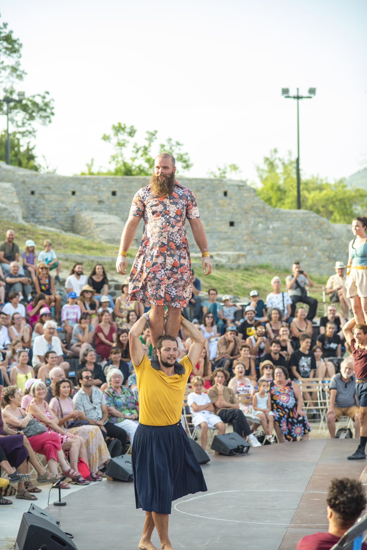 Festival d'Alba 2023. Acrobate en robe devant le public installé dans le Théâtre Antique D'Alba la Romaine